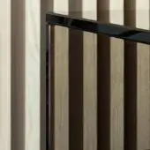 Television screen with bronze tint against light wood slatted wall, reflecting vertical lines and creating shadow patterns.