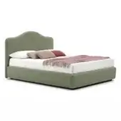 Green velvet bed frame with curved headboard and white bedding, terracotta pillow, and light-brown throw, minimalist design.