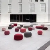 Elegant Lapalma Kipu outdoor ottoman with rounded form upholstered in reds, pinks, browns, and grays with water-resistant textile finish