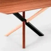 Wood dining table with layered wood-grain top and geometric base featuring black, beige supports and a cylindrical reddish-brown leg.