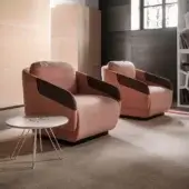 Distinctive Casamania Worn lounge chair upholstered in muted pink fabric with faux leather armrests and a dark base