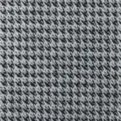 Fabric texture sample, grayscale palette, diagonally oriented repeating pattern of small irregular shapes, woven appearance, possible wool blend.