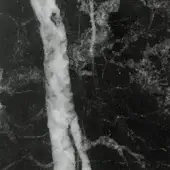 Matt statuario black marble texture with irregular white and light gray veins, displaying a subtle grainy surface and vertical streaks.