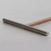 Brushed steel cylindrical rods intersect on light gray, forming a T-shape with matte finish, wood grain backdrop visible.