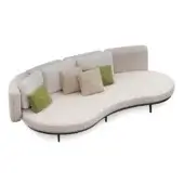 Curved sofa, beige boucle upholstery, black metal frame, with green, linen, and beige accent pillows, studio lighting.