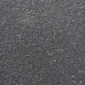 Dark gray asphalt texture with speckled pattern, composed of granular particles and light gray, white flecks, exhibiting a matte, even finish.