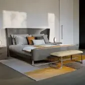 Elegant Turri Milano bed with curved metal base and sophisticated gray textile upholstery offering a contemporary finish