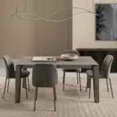 Bontempi dining table with matte gray rectangular top, dark gray base, six sage green upholstered chairs, gray rug, beige ribbed wall panels.