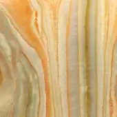 Onyx orange surface displays swirling bands of warm orange, yellow, green, and white with a translucent, organic pattern and even lighting.