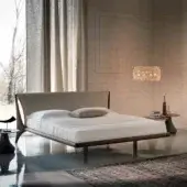 Distinguished Cattelan Italia Nelson bed with curved headboard in light neutral fabric and smooth Canaletto walnut wood frame