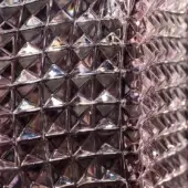 Pink carved crystal “alba” texture displays repeating triangular facets, a three-dimensional geometric pattern, and a glossy, shimmering finish.