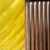Resin and metal texture sample, yellow translucent resin swirl with copper vertical ridges, glossy finish, studio lighting.