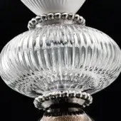Glass globe pendant light, silver metal accents, vertical ribbing, tiered design, conical white element, polished finish, black background.
