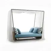 Rattan lounger with light blue fabric cushions, striped & solid pillows, and a sheer white fabric canopy supported by bronze metal poles.