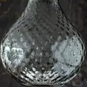 Clear glass Balloton Fume vase, pear-shaped with hammered texture, displays light refraction and a wider base against a dark backdrop.