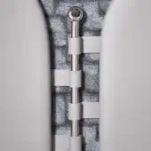 Zipper closure with polished steel sphere pull, light gray leather sleeves, metallic gray strip, and textured gray fabric background.