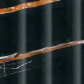 Dark stone texture with diagonal orange and white bands, featuring granular patterns and subtle sheen against a grainy black background.