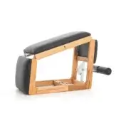 Pilates reformer, light wood frame, black leather upholstery, rectangular panels, hand crank mechanism, adjustable resistance levels.