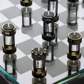 Chess set, gold and chrome, cylindrical pieces with black and clear acrylic cores on a black and white checkered game board with reflective surface.