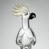 Glass parrot sculpture, clear and gold, with curved body, black beak, translucent crest, and blown glass construction.