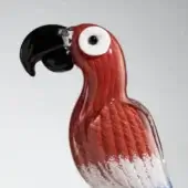 Glass parrot sculpture, reddish-orange and white, featuring swirling patterns, black beak, and a glossy, translucent feather design.