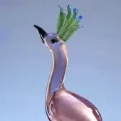 Glass peacock sculpture, rose-pink with gold shimmer, elongated form and fan-shaped crest of green-blue glass elements, glossy finish.