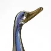 Glass duck sculpture, blue and gold, with slender neck and amber beak, displayed on white background.