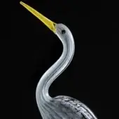 Glass stork sculpture, translucent grey, curved neck and body, yellow beak, black eye, minimalist display, smooth glossy finish.