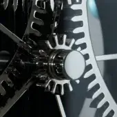 Palladium coated brass gears, interlocking white and black mechanical sculpture, central dark gray sphere, detailed tooth patterns.