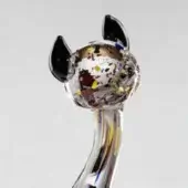 Glass cat sculpture, clear with multicolored fragments, featuring a curved neck with vertical yellow, blue, and white stripes.