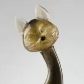 Glass cat figurine, mottled gold and grey, sculpted with textured fur, pointed ears, and black bead eye against a grey backdrop.