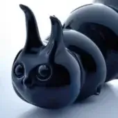 Black ceramic caterpillar sculpture with rounded segments, curved horns, and glossy polished finish on a white surface.