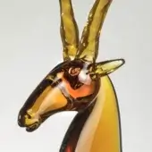 Glass antelope sculpture, amber and gold, stylized head with translucent horns and striped neck, glossy finish, studio shot.
