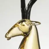 Glass antelope ox sculpture, amber-gold and black, stylized form with curved horns and detailed head, smooth polished surface.