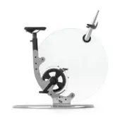 Chrome exercise bike with transparent circular wheel, silver metal frame, black padded seat, and conical accessory, studio shot.
