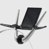 Chrome exercise bike handlebar with curved tubular design, black plastic tablet holder, circular clamp, and transparent cables on gray background.