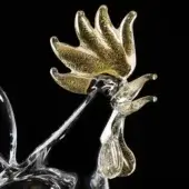 Glass rooster sculpture, clear glass with gold leaf, stylized head and feathered tail, black background.