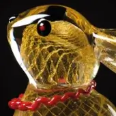 Glass rabbit sculpture, amber translucent glass, gold latticework detail, red glass eye and twisted collar, stylized form, glossy finish.