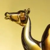 Glass camel and dromedary sculpture, amber tone, detailed forms with elongated necks and subtle integrated text.