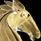 Glass horse head sculpture, gold inclusion, stylized profile, translucent ears, dark metal neck band, black background.