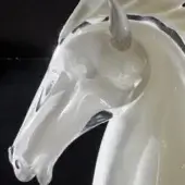 Glass horse head sculpture, clear with dark gray accents, depicting a profile view with detailed facial features and a glossy finish.