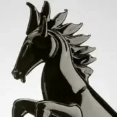 Horse sculpture black lacquered rearing pose, geometric form with angled planes, modern design against a white backdrop.