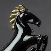 Horse sculpture, black ceramic, rearing pose with gold mane and tail, white stripe detail, glossy finish, dynamic composition, dark gray background.