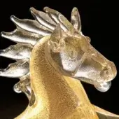 Glass horse sculpture with gold flecks, dynamic pose, clear head and legs, swirling gold interior, studio shot, black background.