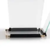 Gold plated tray with black oak surface, rectangular shape, and patterned frame, flanked by angled clear acrylic panels.