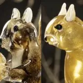 Glass squirrel figurines, amber and gold tones, stylized design with upright posture and reflective glossy finish.