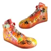 Orange sneaker sculptures by Juliarte with iridescent finish, black graffiti, and athletic shoe design details against a white backdrop.