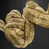 Brass sculptural pendant light, interwoven ribbon forms, textured golden finish, dynamic arrangement, diffused internal glow, dark background.