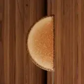 Caramel confection, amber-brown, half-moon shape displayed against dark wood paneling with granulated sugar crust and “brown – borealis” text.