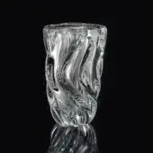 Clear glass vase, polished finish, organic swirling shape with internal patterns, asymmetrical form, dark reflection on black surface.